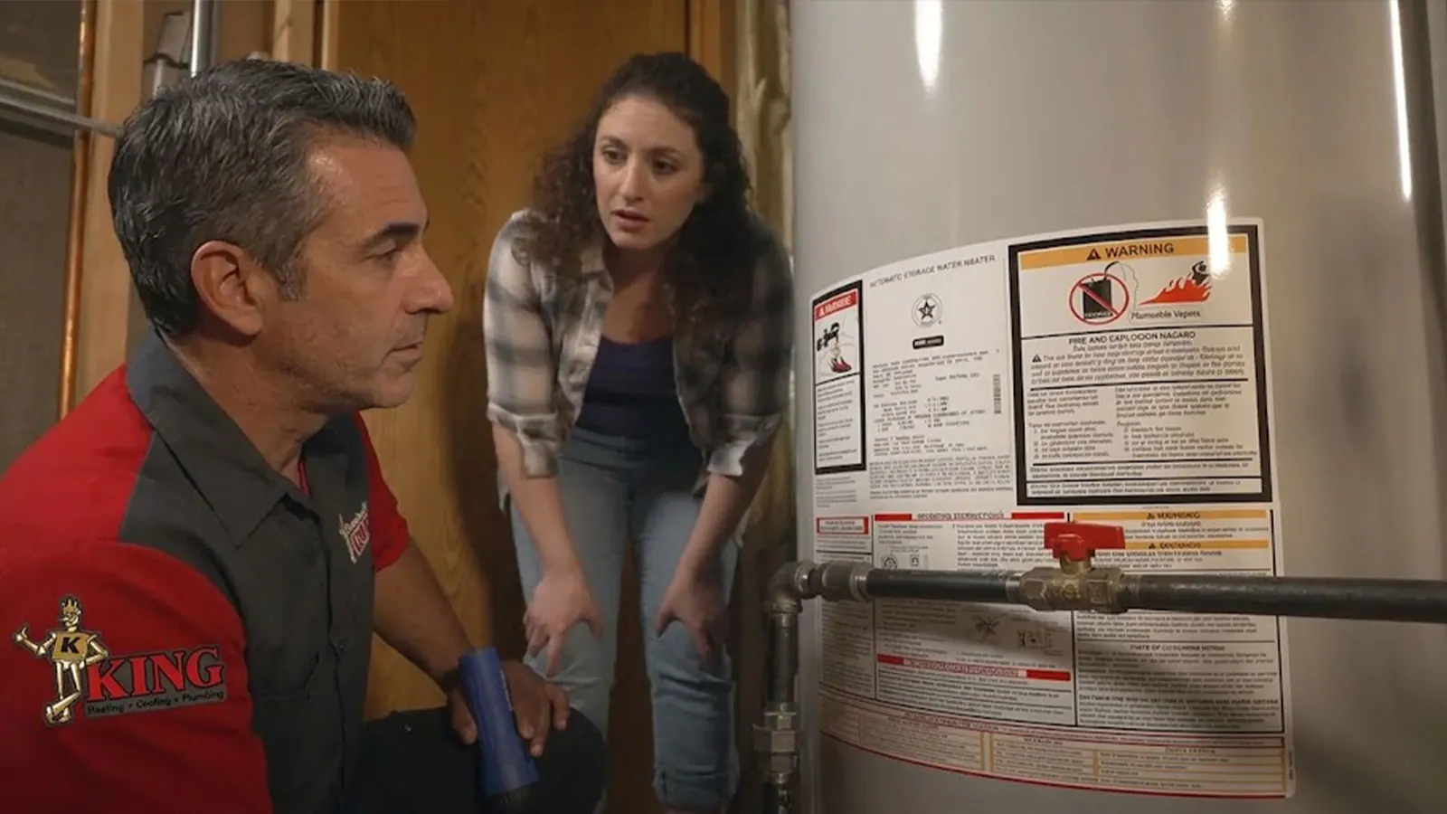 A King plumber working on a tank water heater